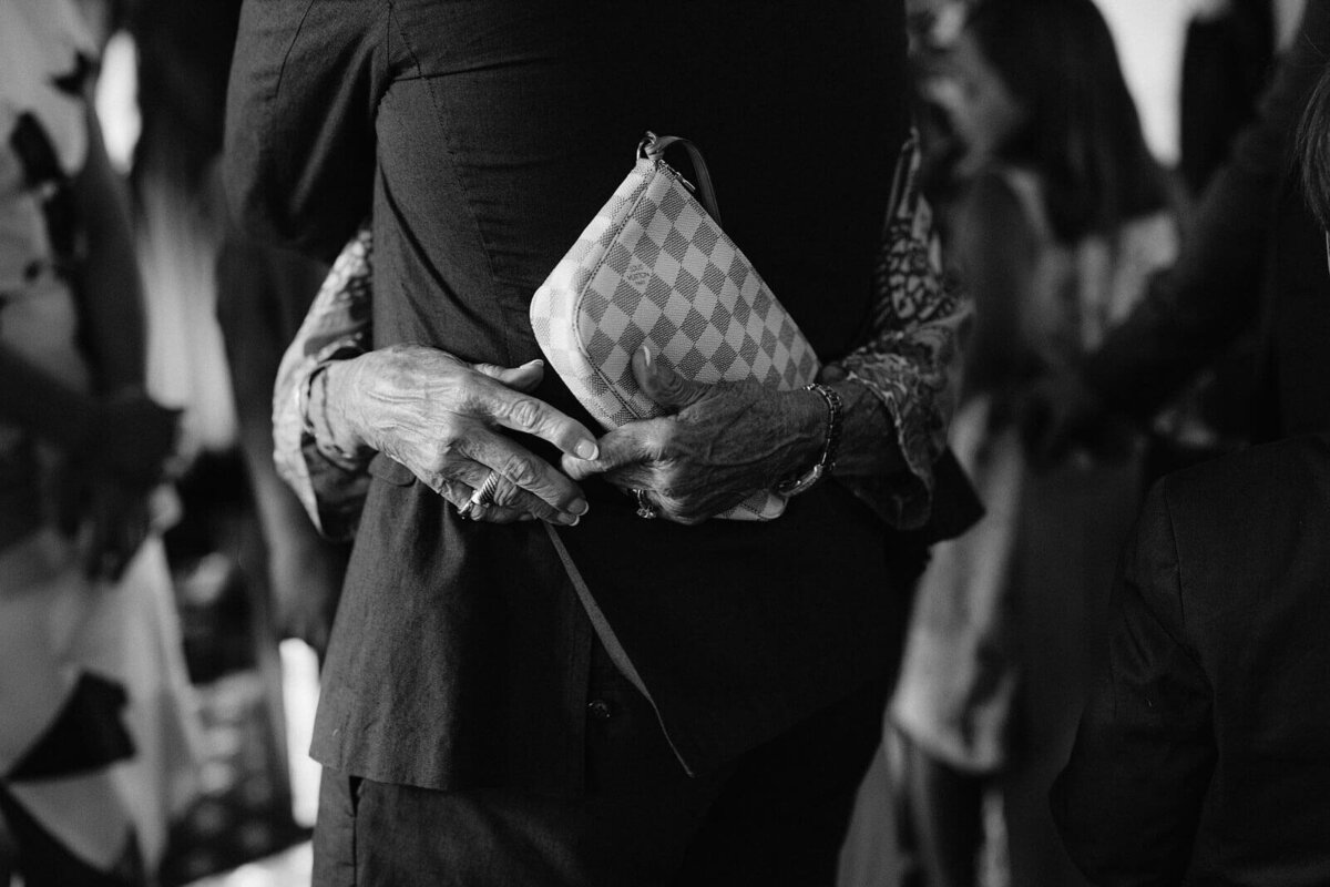 Black and white photo of an old woman's hand holding a purse while hugging a man at Wianno Club, Cape Cod.