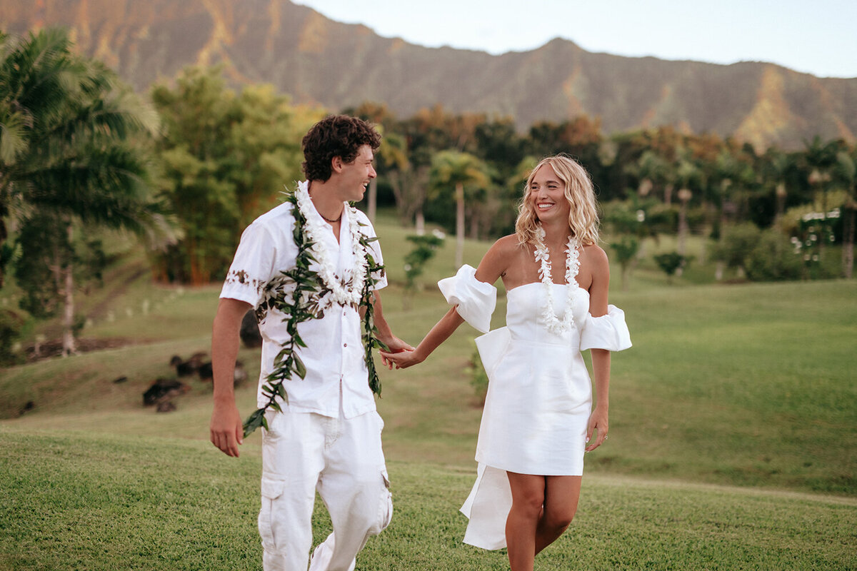 Bride and groom in Hawaii holding hands and laughing