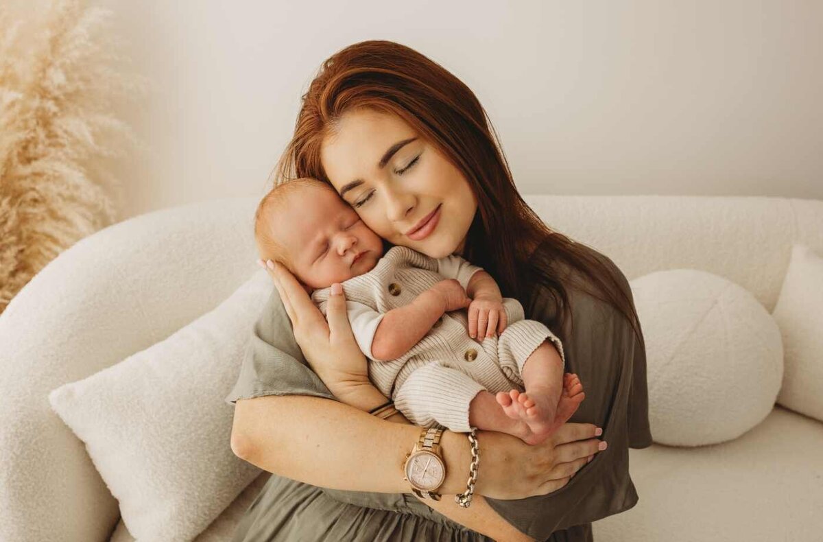 Ruua Hamdan Photography (UK): A mother is holding her baby close, looking lovingly at them.