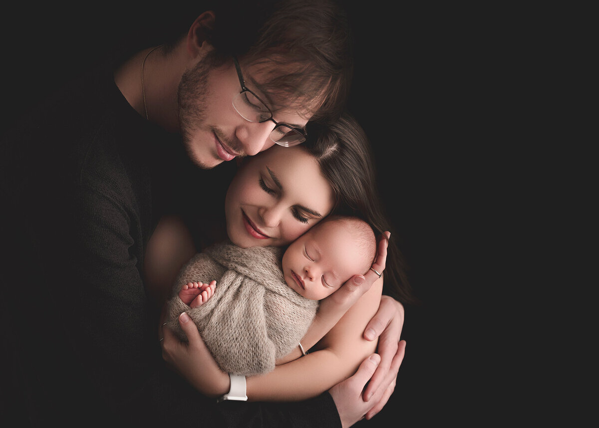 mother, father and baby held tightly wrapped up with emotion in syracuse new york studio