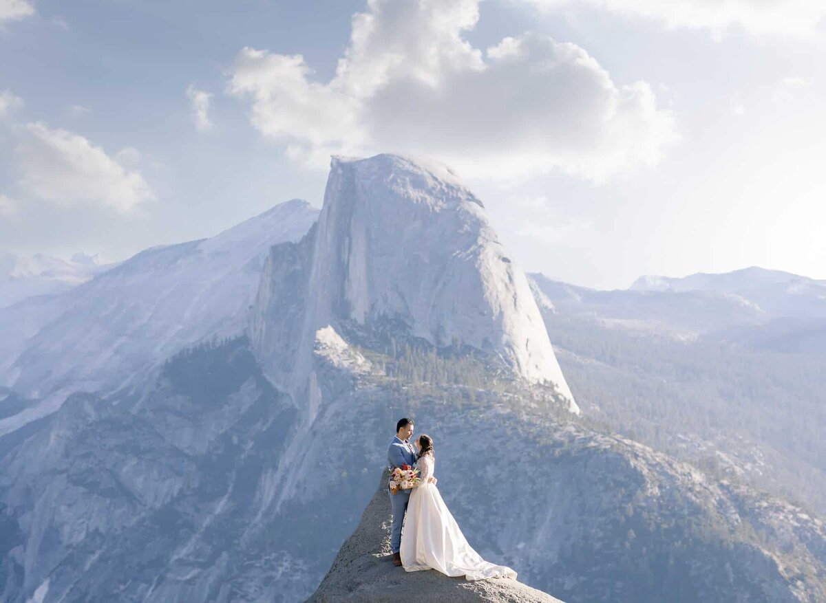 A couple enjoys their wedding day in front of the iconic half dome, from the view of Glacier Point in Yosemite National Park.