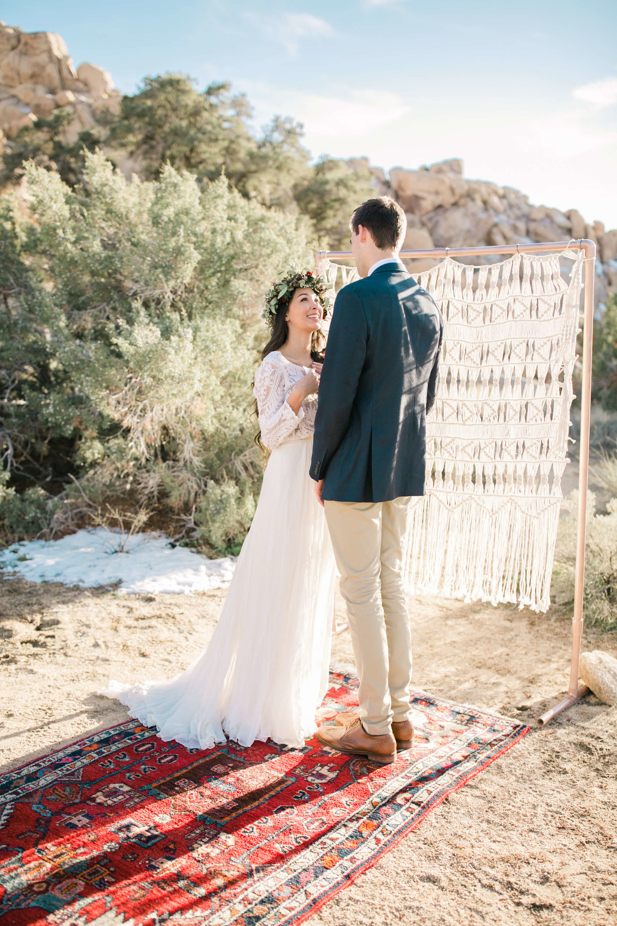during their joshua tree elopement ceremony the bride looks up at her groom, smiling