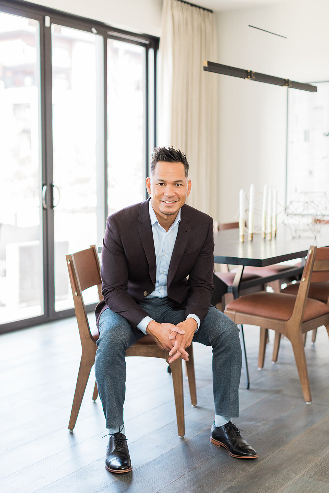 Brand photo of Calgary business man leaning forward casually in a wood and leather chair 