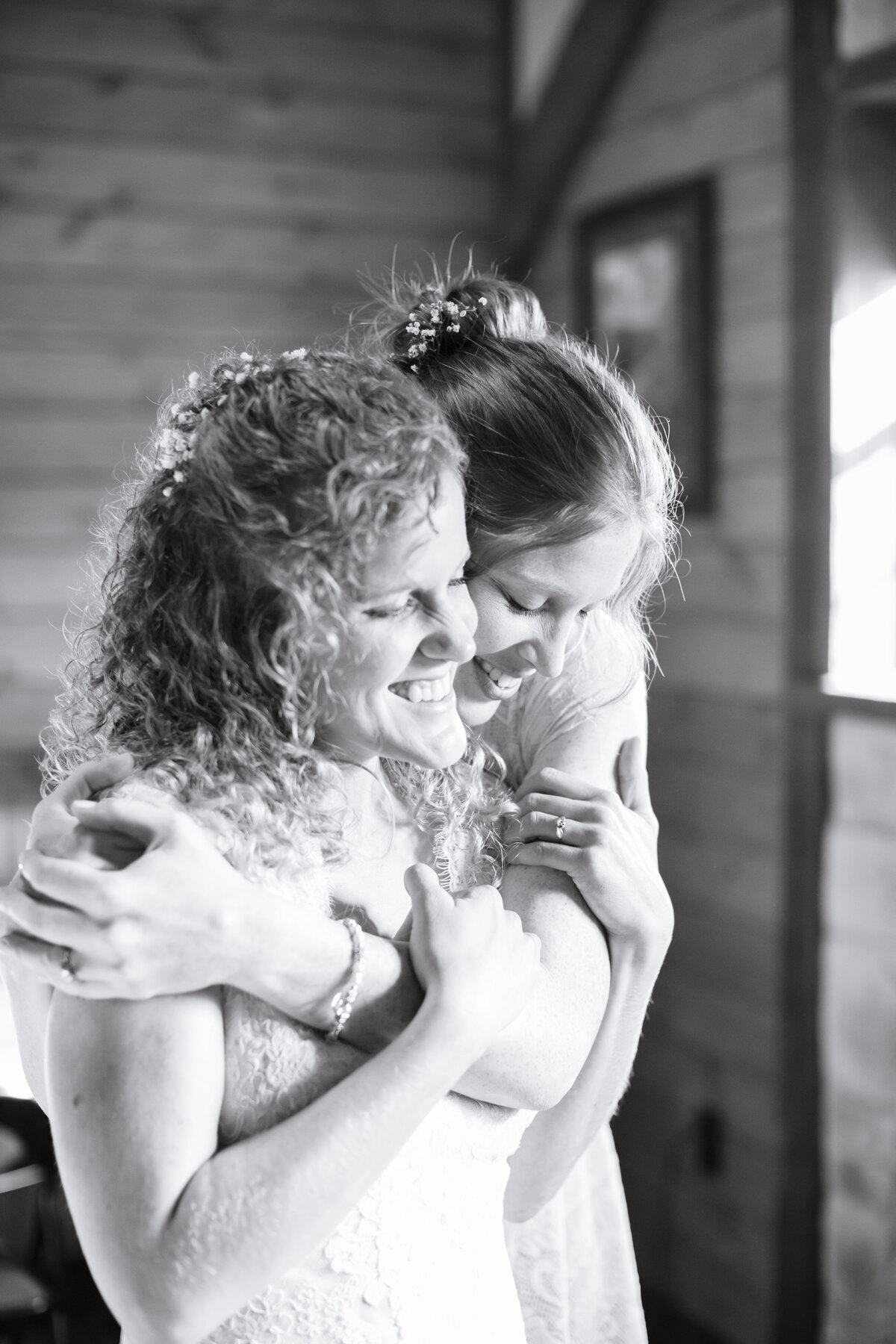bride's sister gives hug in black and white image at wedding near Austin Texas