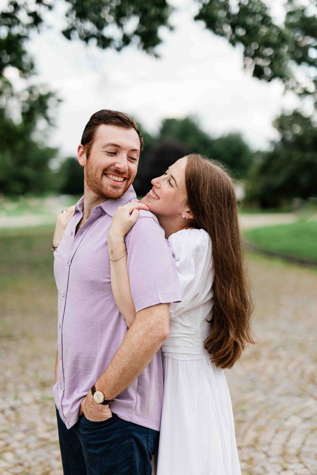 Couple holding on to each other on top of stone pathway, smiling