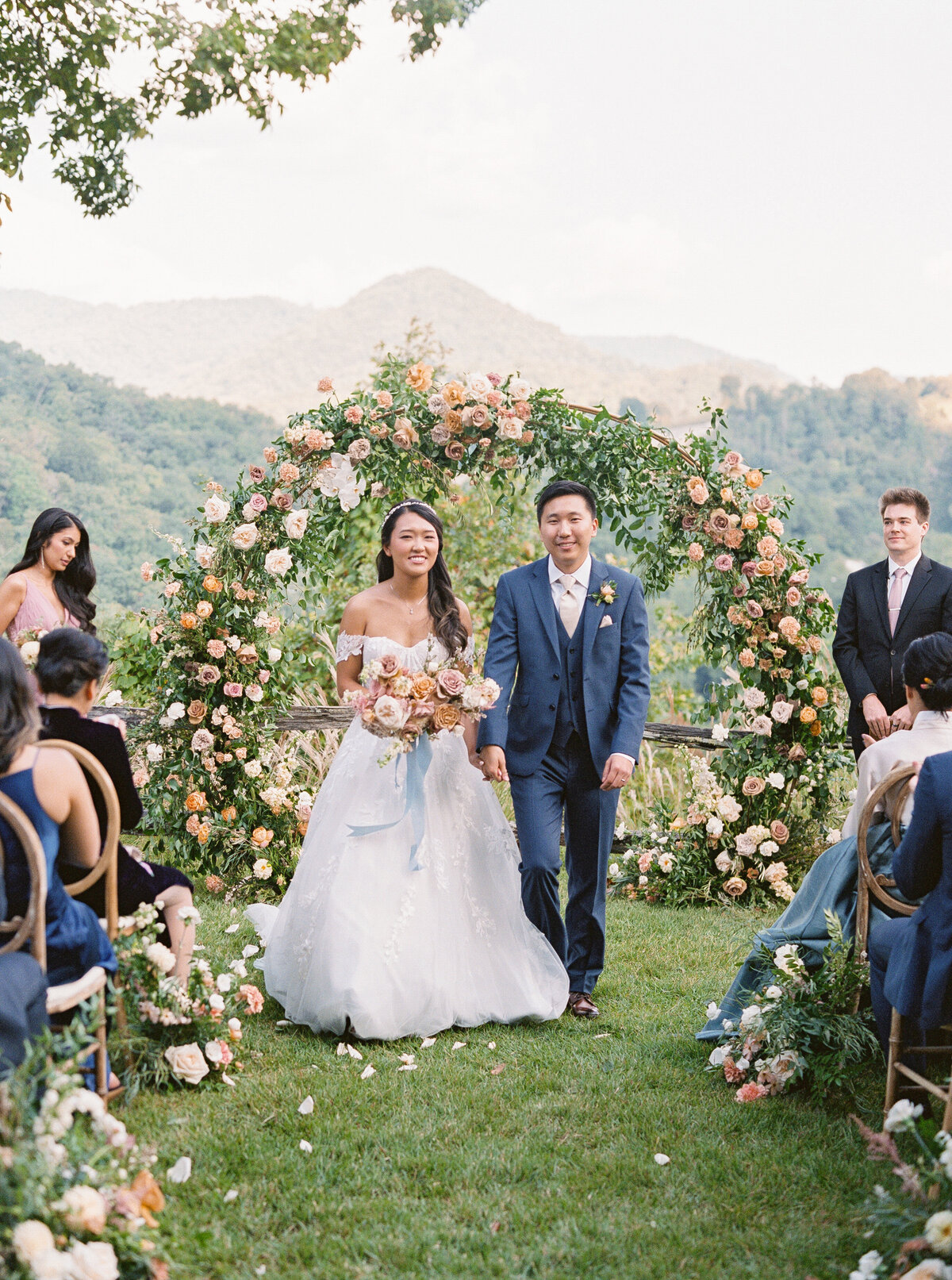 Bride and groom walking back up the aisle smiling after their ceremony at Castle Ladyhawke in North Carolina.