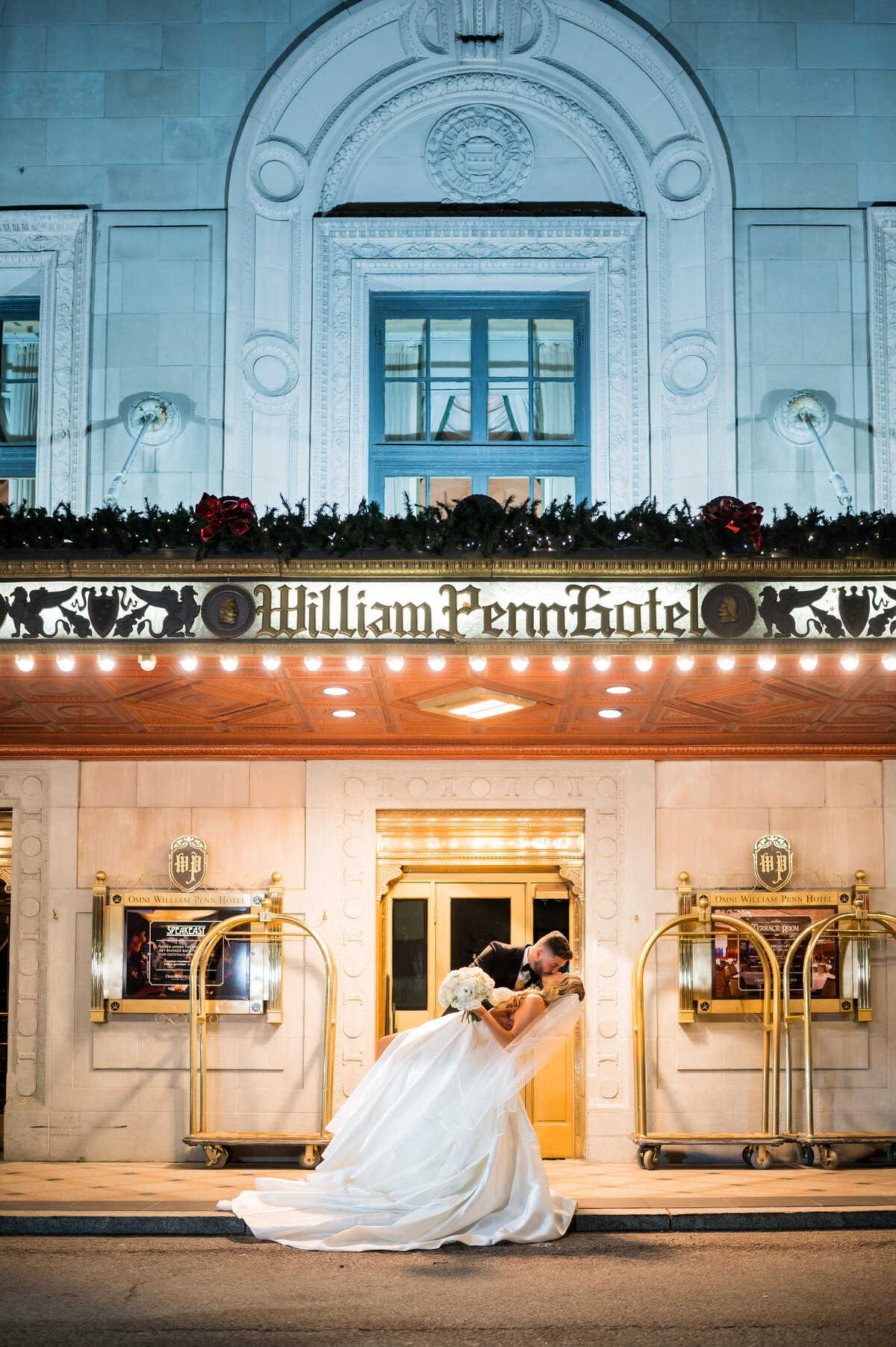 bride and groom kissing in front of the omni
