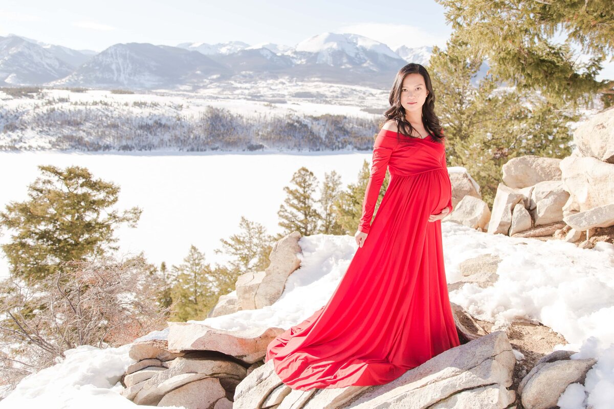 red maternity gown and baby bump  with Dillon Lake in background