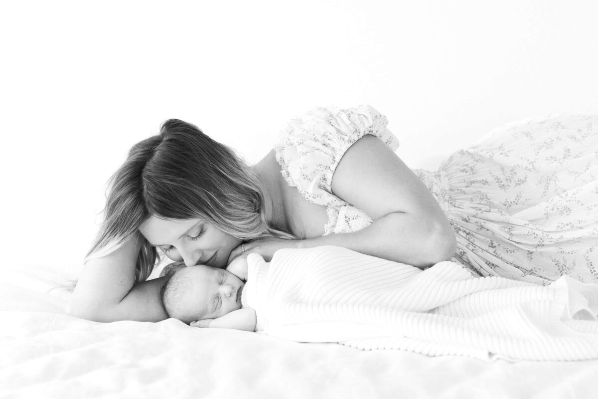 black-and-white-mother-snuggling-newborn-bed-session