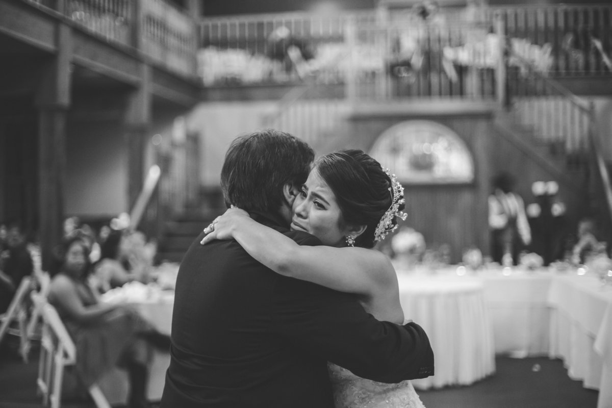 bride cries and hugs her dad during father daughter dance at The Grande Hall at Hoffman Ranch wedding venue in Castroville