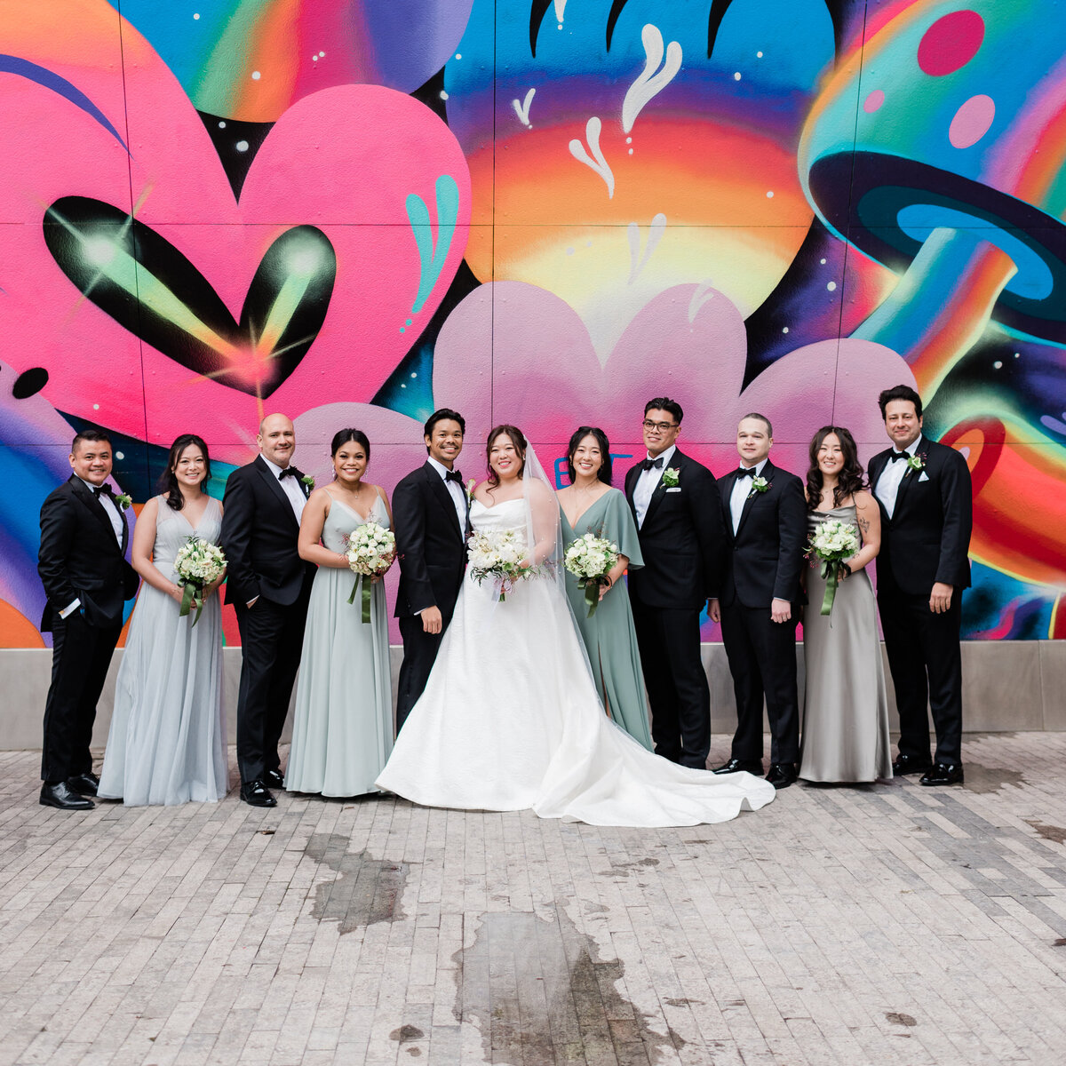 Bridal party stands outside an NYC mural