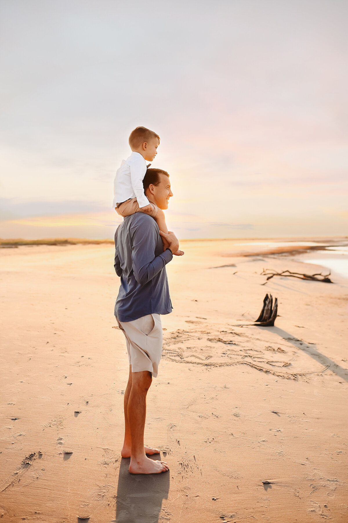 Father carries his young son on his shoulders during Family Photos on Folly Beach.