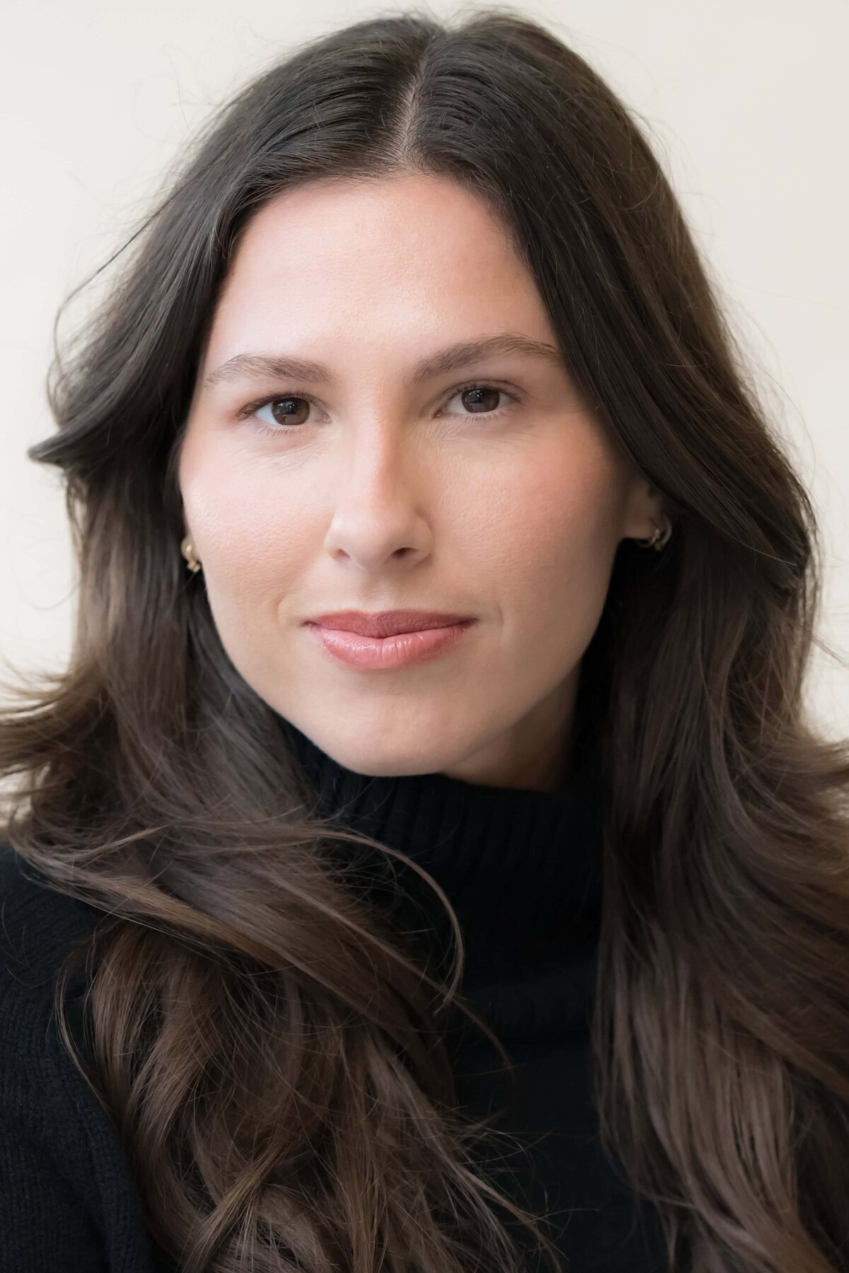 Close-up photo of a stunning woman with long dark hair looking serious
