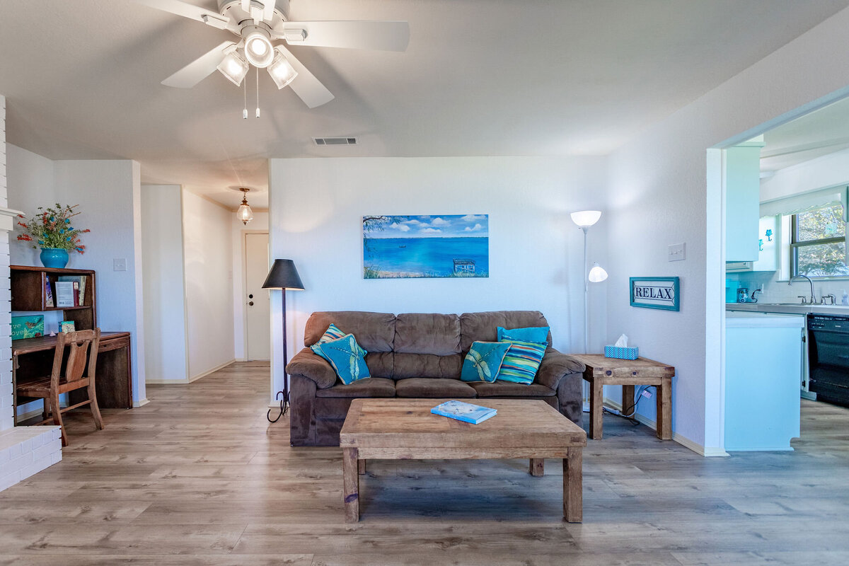 Living room with desk space and smart TV in this 2-bedroom, 2-bathroom lakeside vacation rental home for 6 guests on Tradinghouse Lake with privacy access to a fishing dock and boat launch pad, ping pong table, gazebo, free wifi and free parking in Waco, TX.