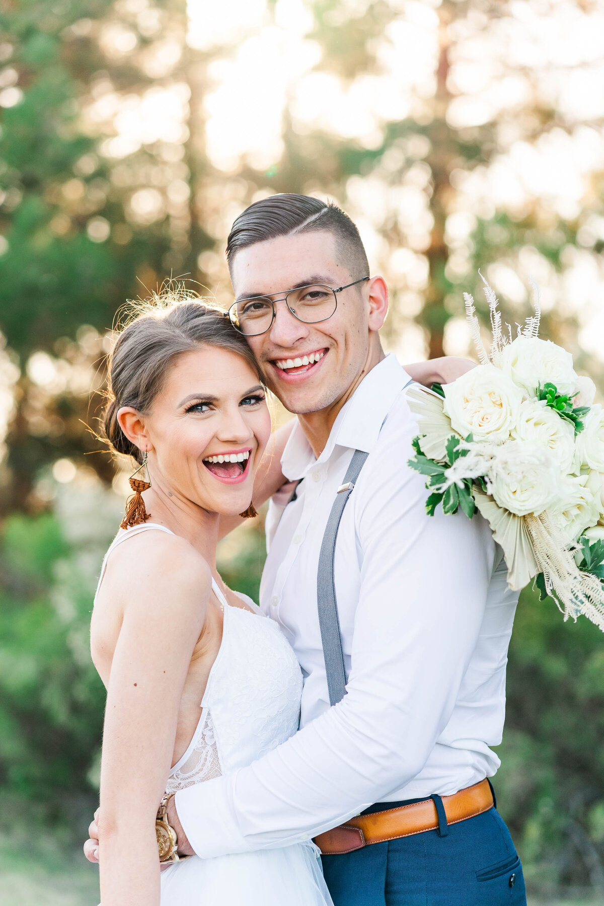 Bride and groom smiling on their wedding day with white bouquet