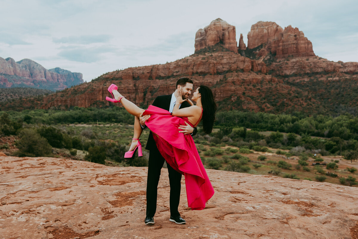 couple with bright colors takes a photo in front of cathedral rock in sedona