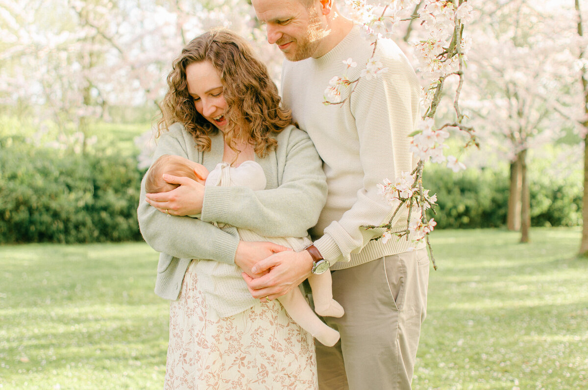 Family cuddles in during a photoshoot under the cherry blossoms in Amsterdam.