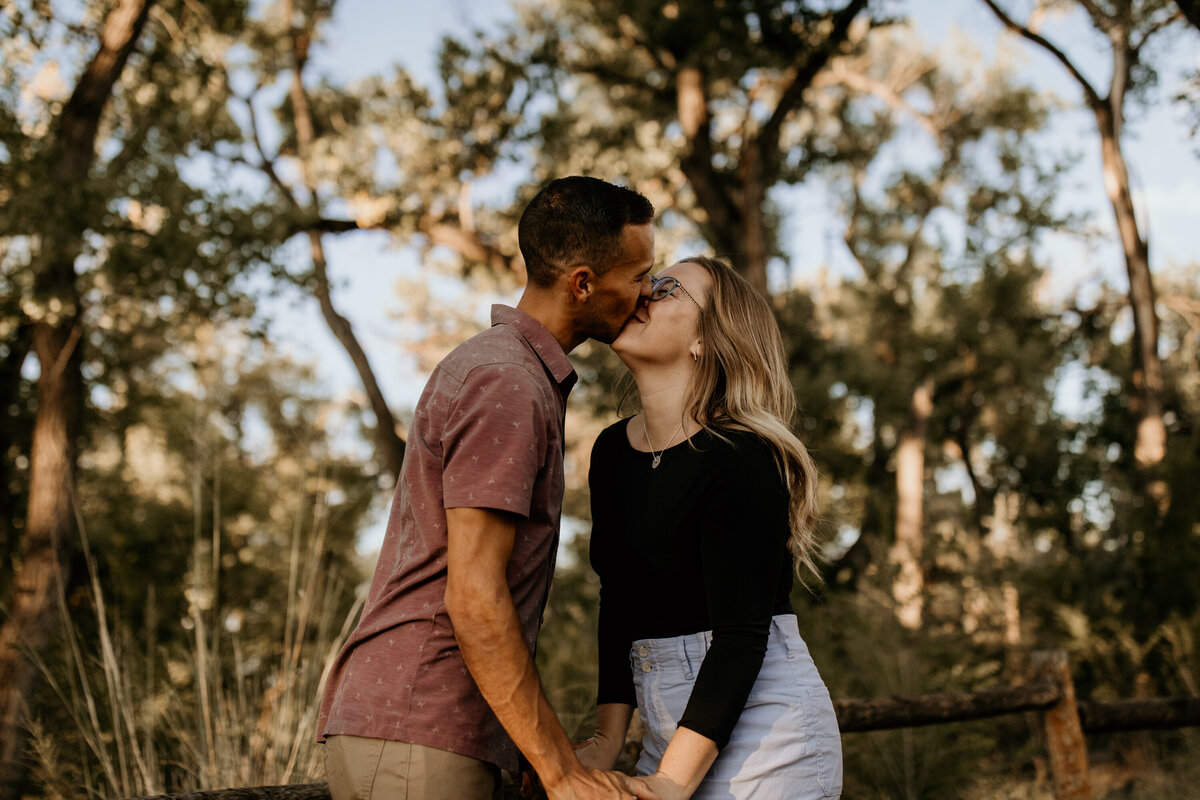 engaged couple kissing at the Bosque in Albuquerque