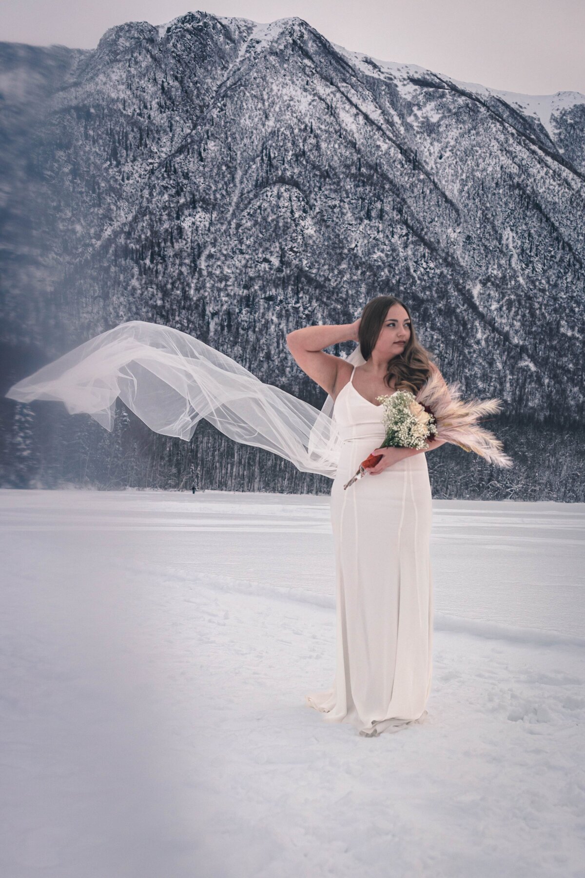 A stunning bride in front of Alaska Mountains on Mirror Lake