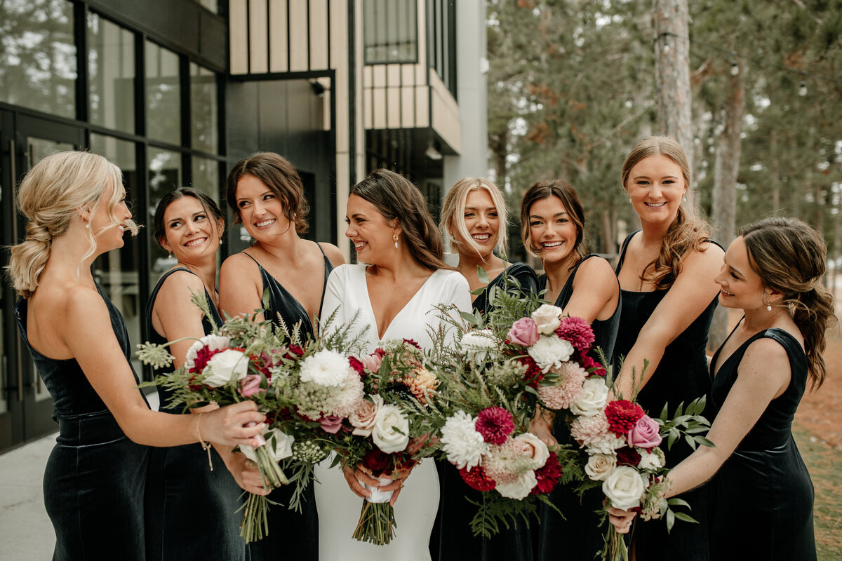 Bridesmaids surround the bride with gorgeous bouquets during a modern wedding at Catalyst by NatureLink.