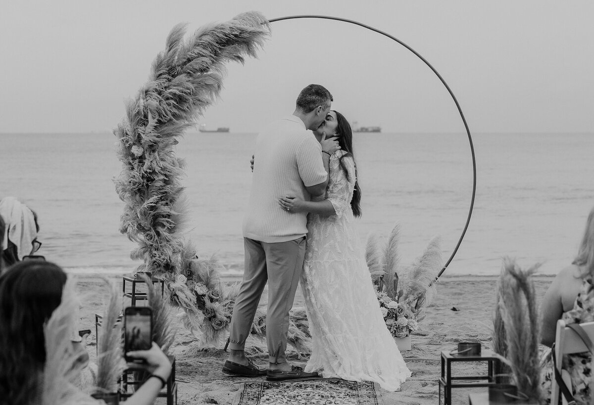 couple kisses during ceremony on beach