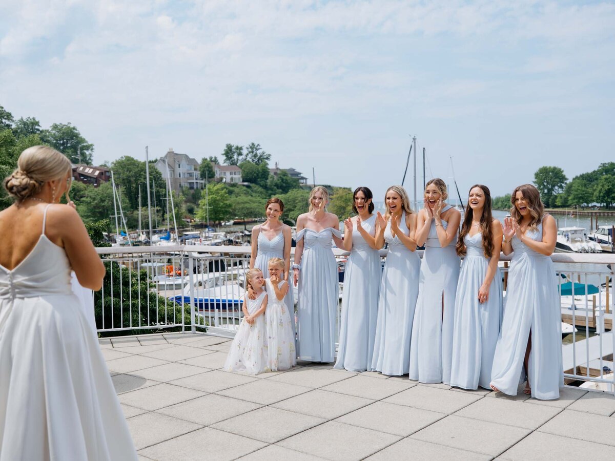 Bride's first look with bridesmaids in blue dresses at Cleveland Yachting Club
