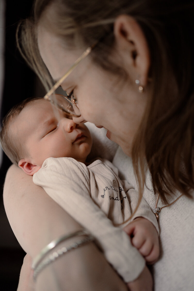 Closup van moeder die haar baby dicht bij haar gezicht houdt en neusje neusje doet