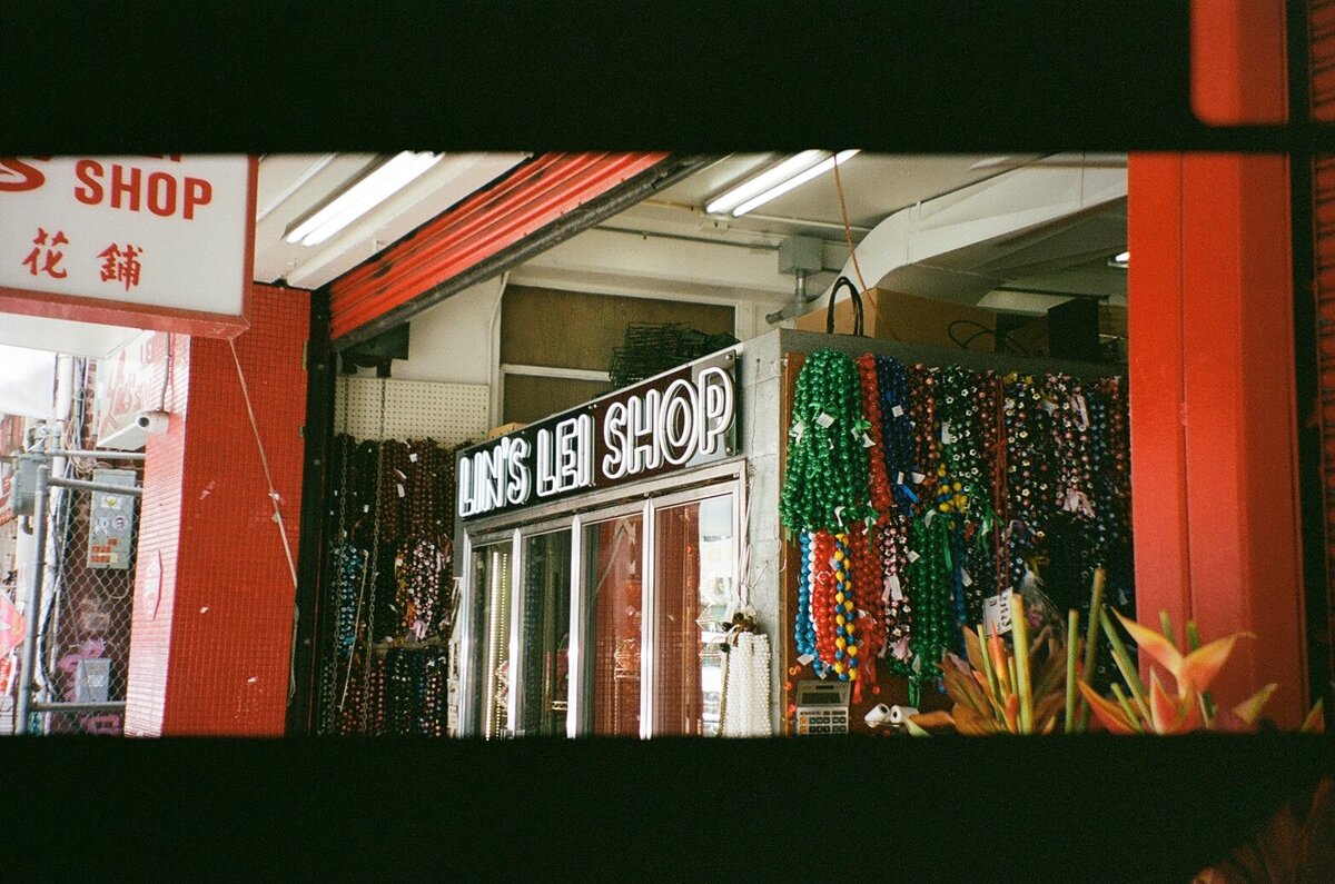 Lei shop in Chinatown captured on analog film by Kate Winters Photography, showcasing the vibrant and cultural details in an authentic, documentary style.