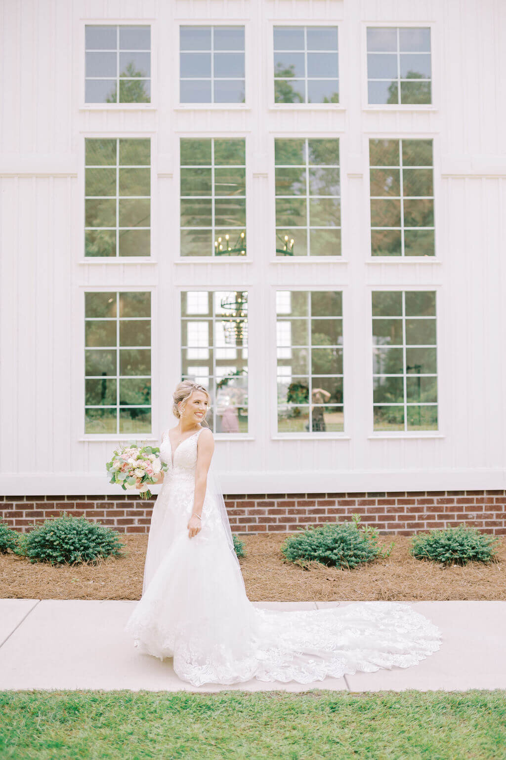 Bride swishing dress and laughing during bridal portraits