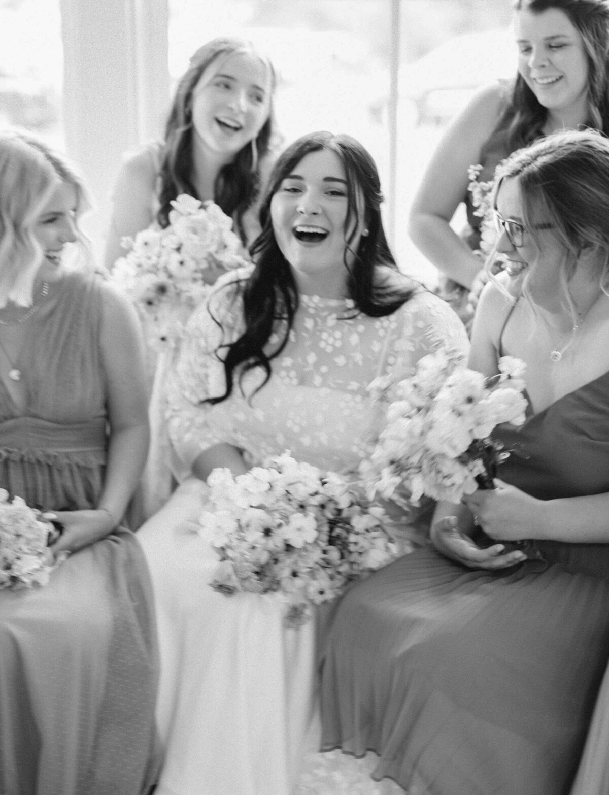 bride laughs with bridesmaids, Michigan candid wedding photographer