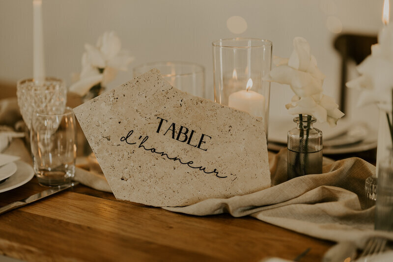 Décor sur lequel figure l'inscription "table d'honneur", posé sur une table en bois décorée pour un mariage immortalisée par Laura, photographe professionnelle en Vendée.