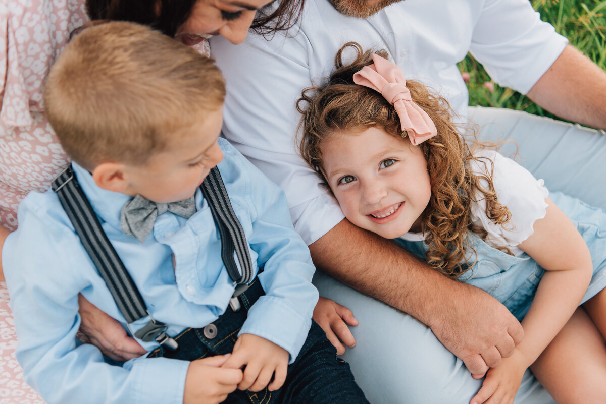 Close up of family of four, snuggling in field