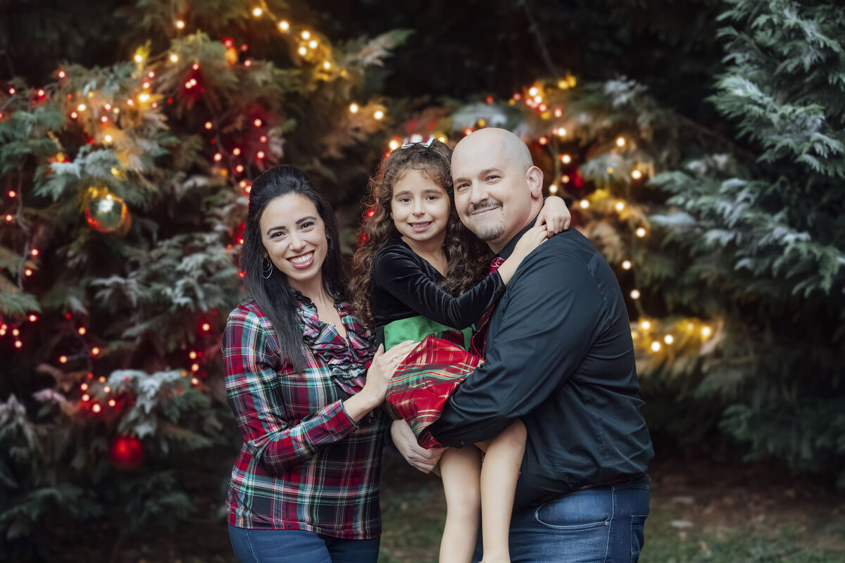 Christmas Photographer | Family posing together in festive holiday setting during Christmas portrait session | New Jersey