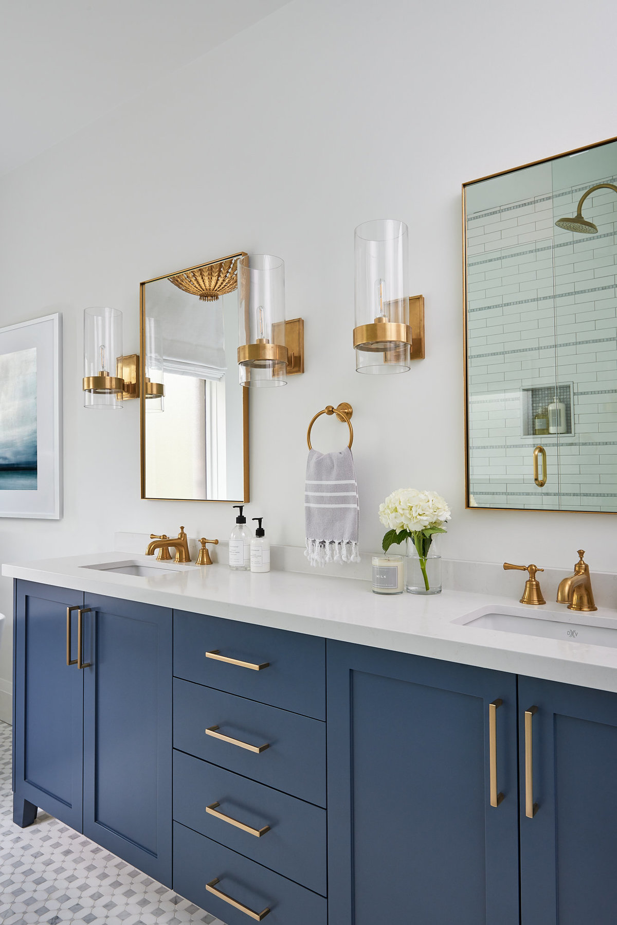 custom navy vanity in Toronto bathroom with gold mirrors and wall sconce lighting above