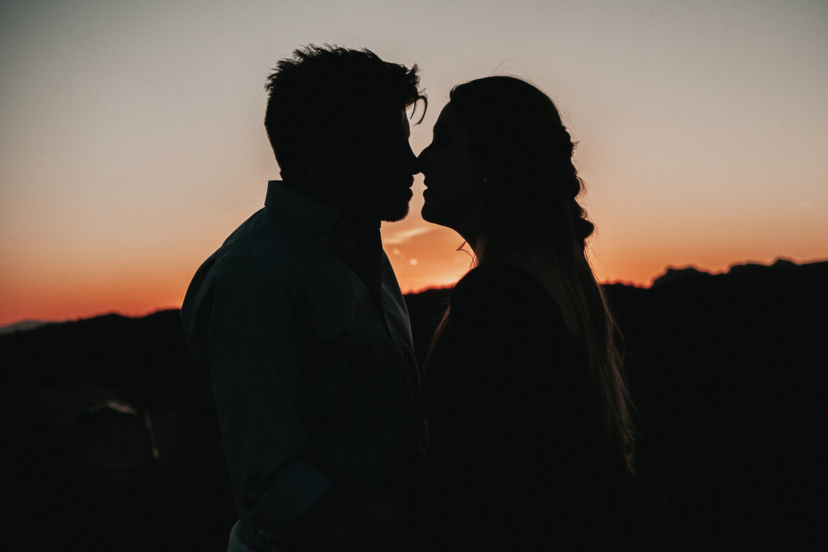 Engagement couple silhouetted at sunset during their engagement photography session