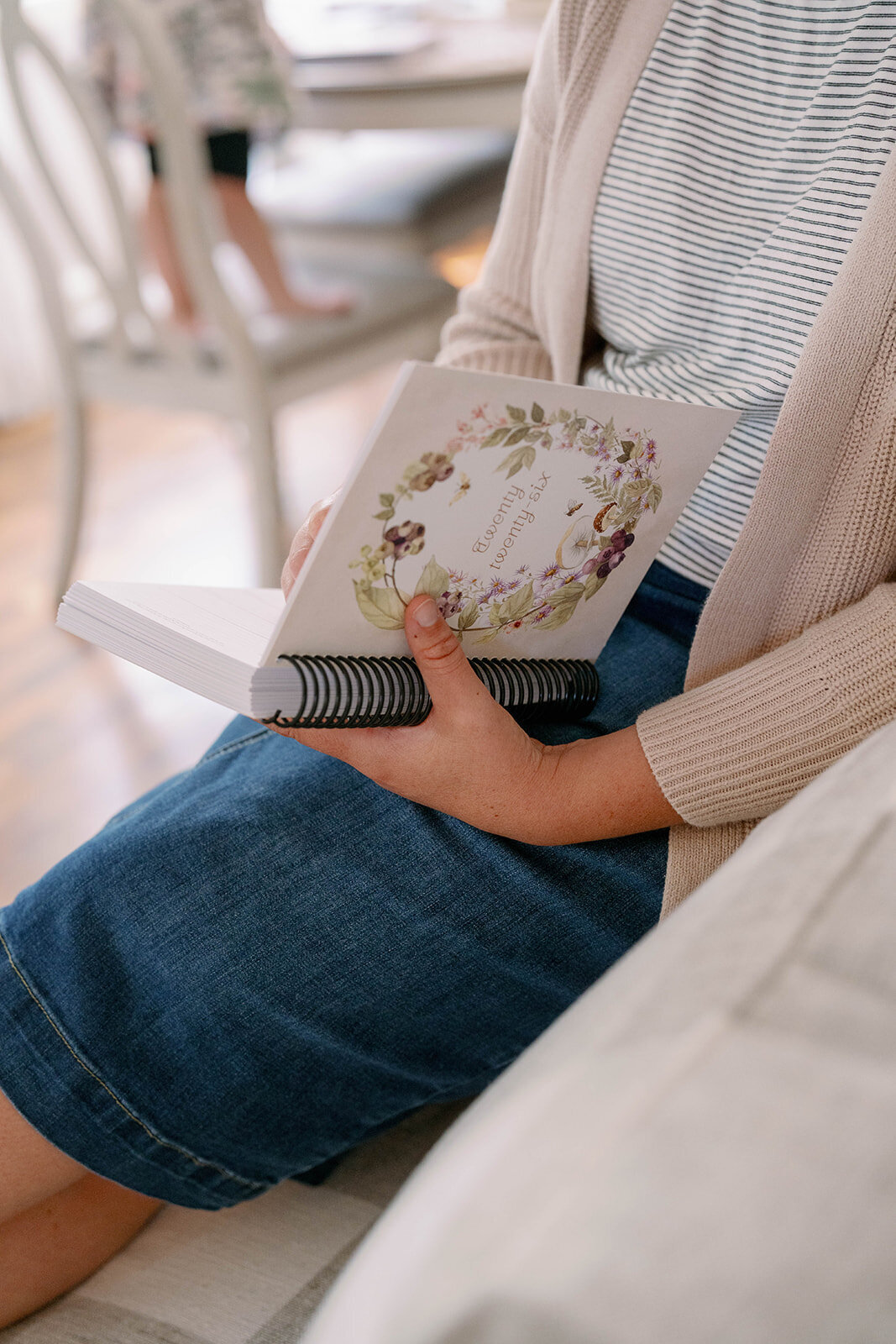 Close-up of a floral planner resting on a woman's lap during the planner company branding session in Indiana.