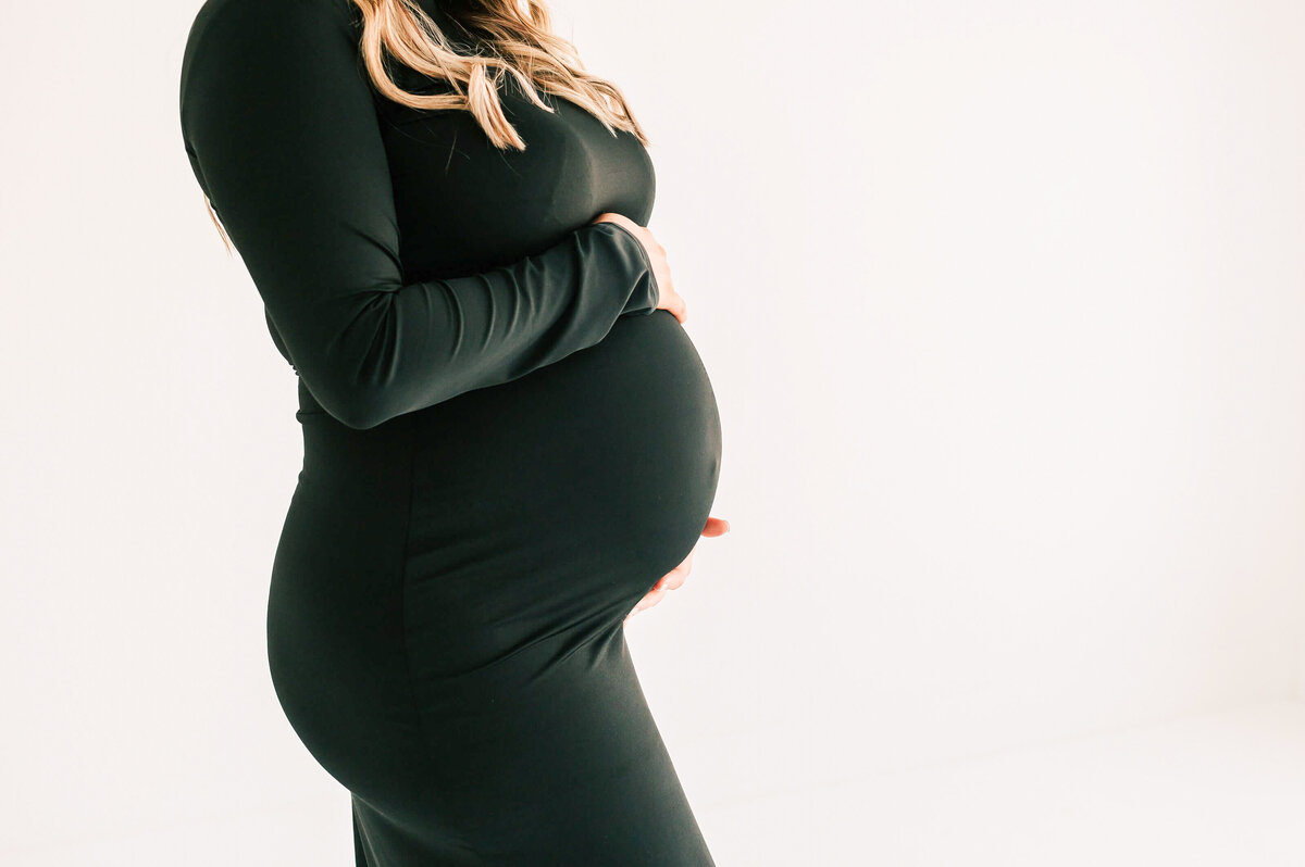 close up of baby bump in black dress