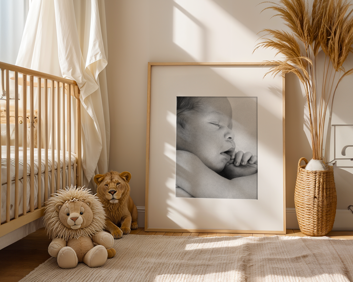 example mockup of a framed newborn photo sitting again wall next to crib