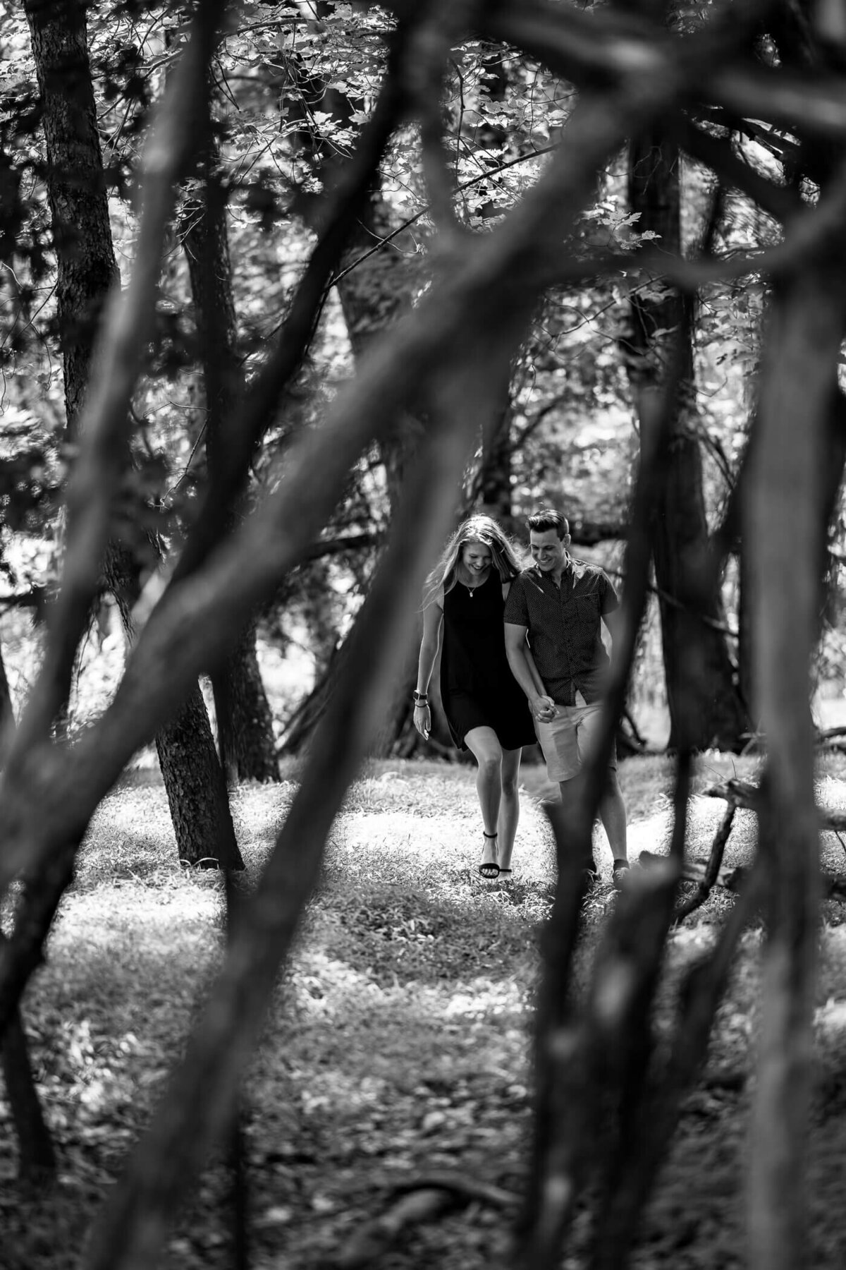 Blakc and White portrait of Deidra and Michael walking and talking together in the woods of a local Pennsylvania park