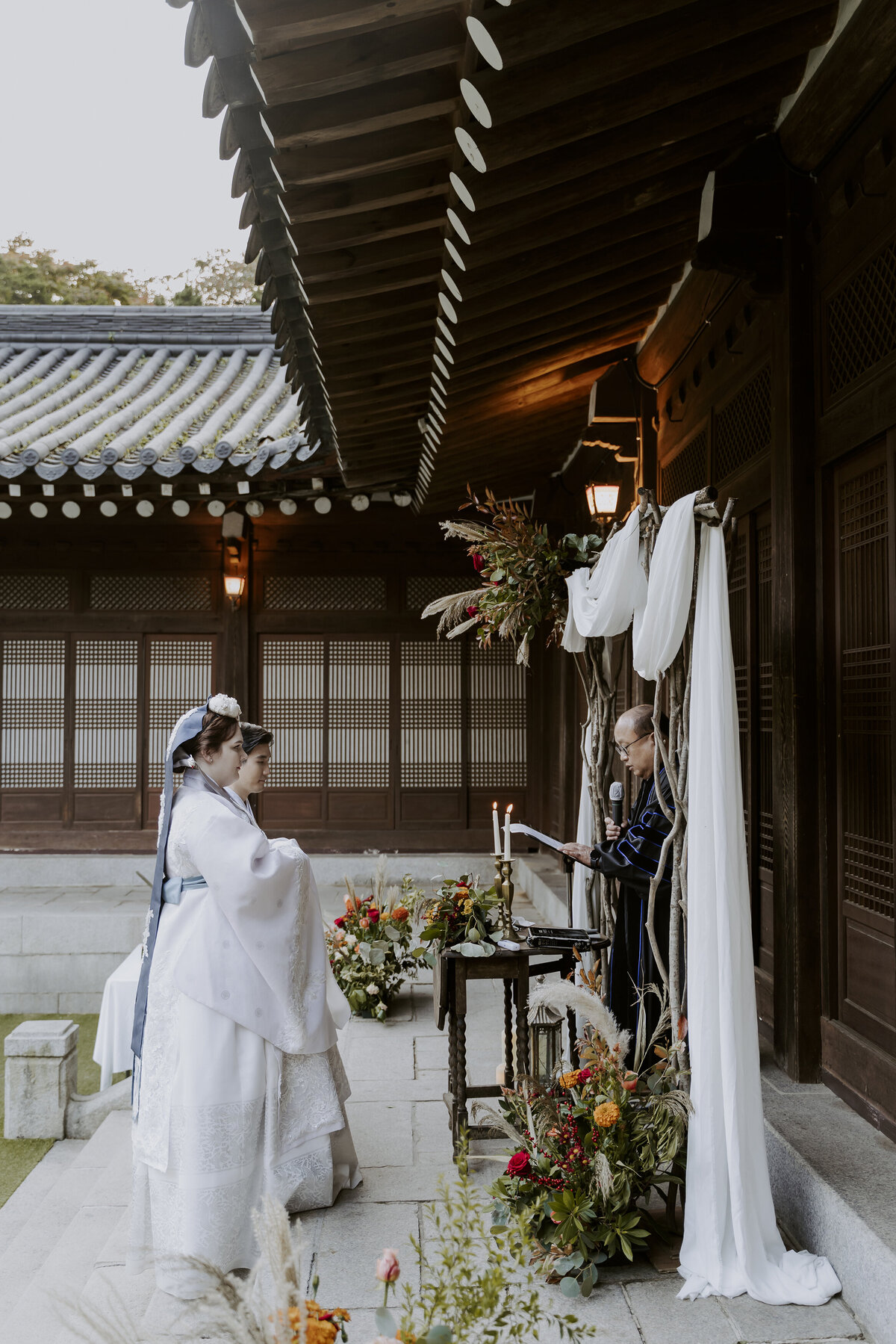 couple dressed in white hanbok at their wedding ceremony in seoul