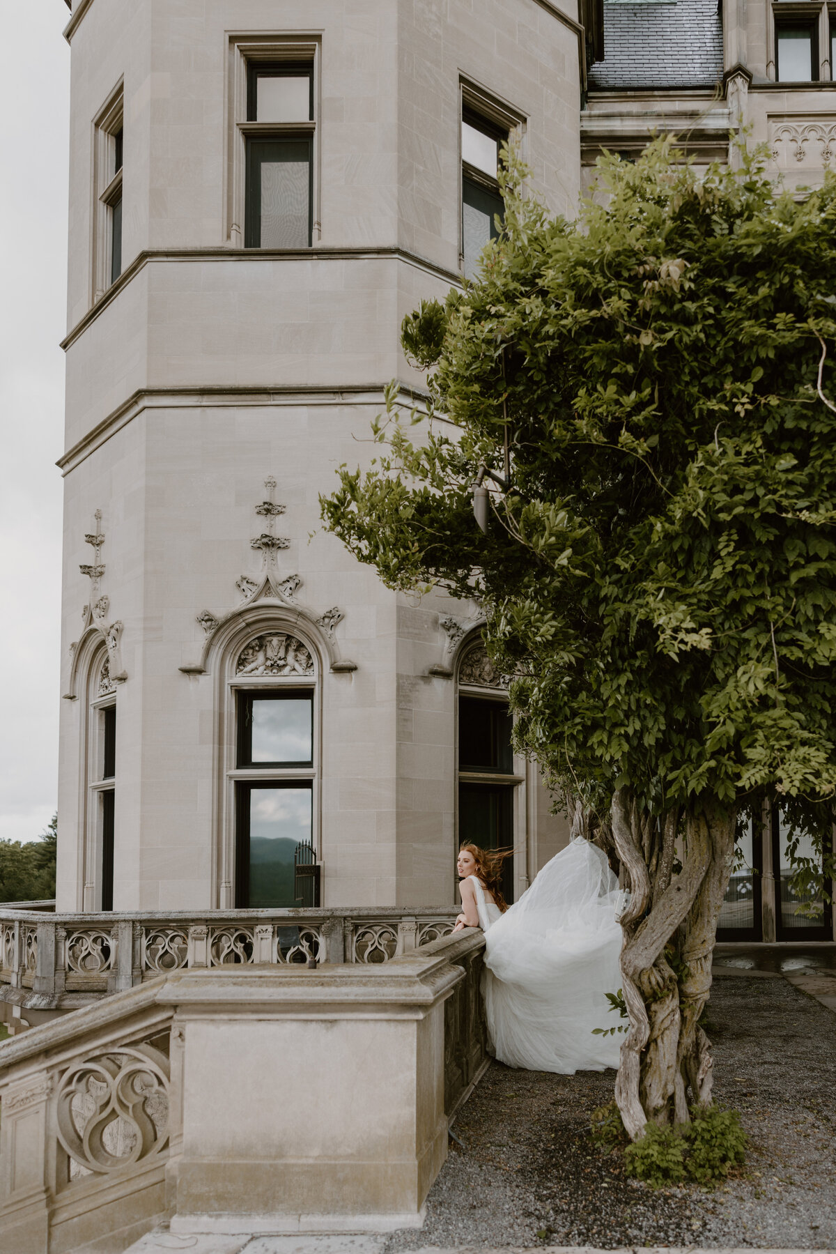 Bride standing under stone archways at the Biltmore, wearing a flowy Anthropologie wedding gown.