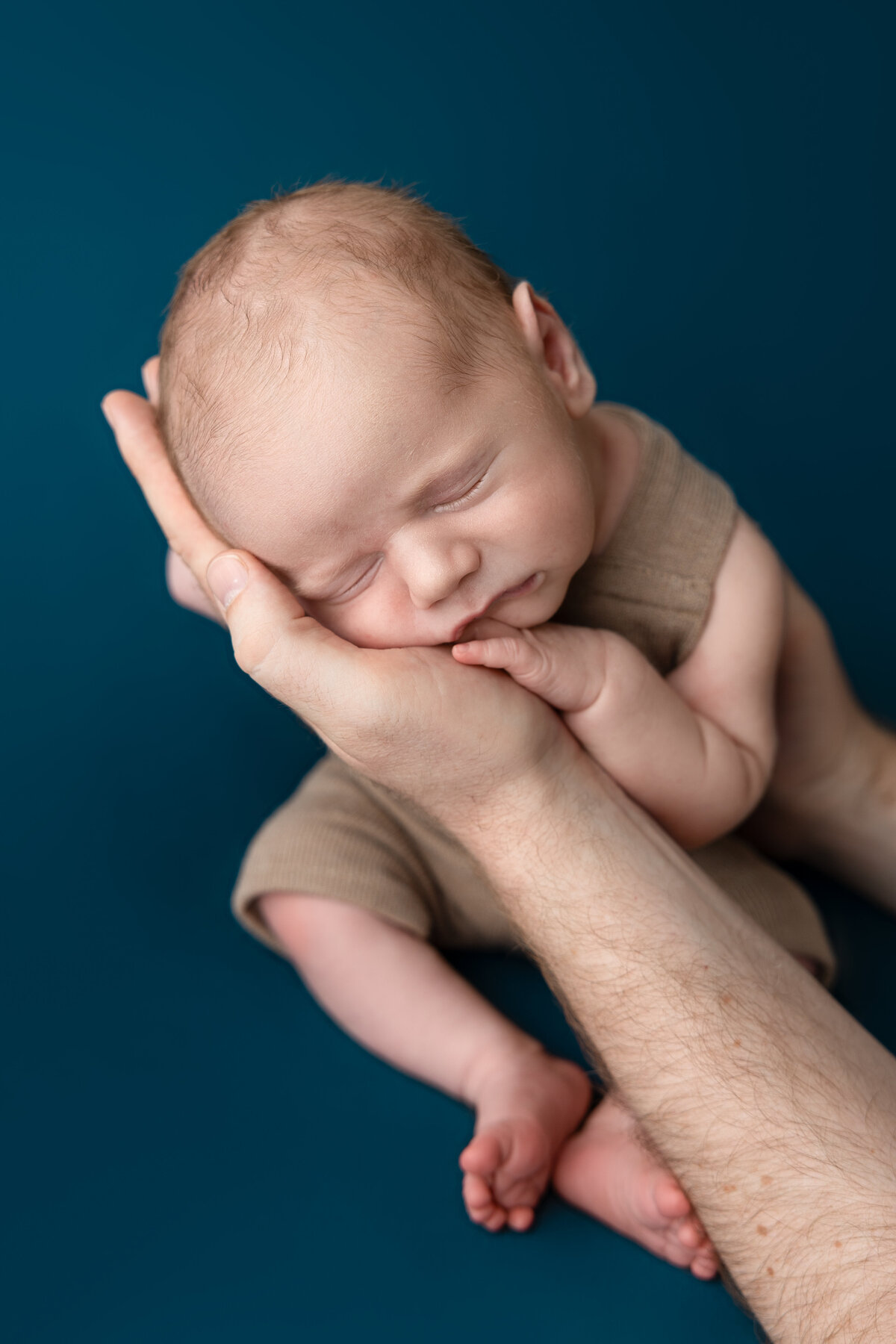 Baby posed in dads hand