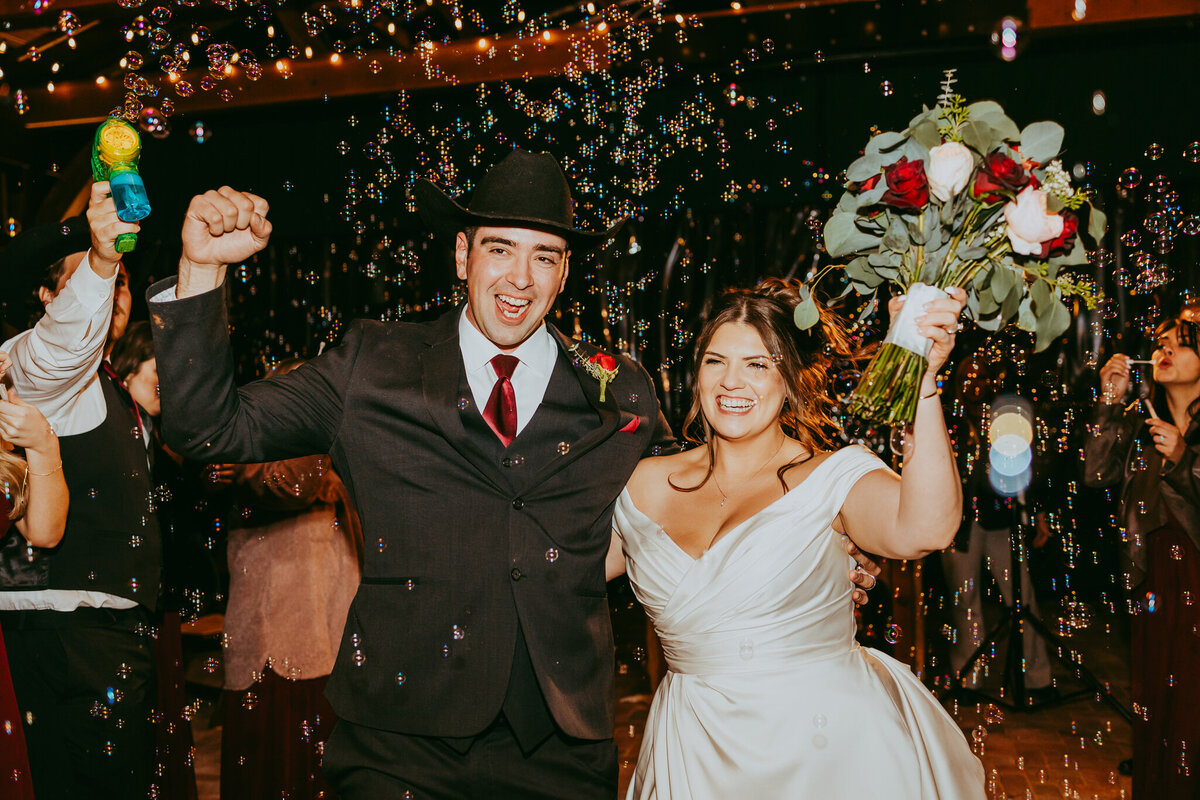 wedding photo of couple smiling through bubble exit