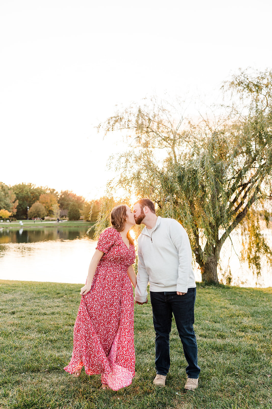 Pregnant couple standing outside holding sonogram images
