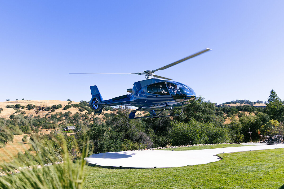 blue helicopter airbus landing on golf course for easy travel