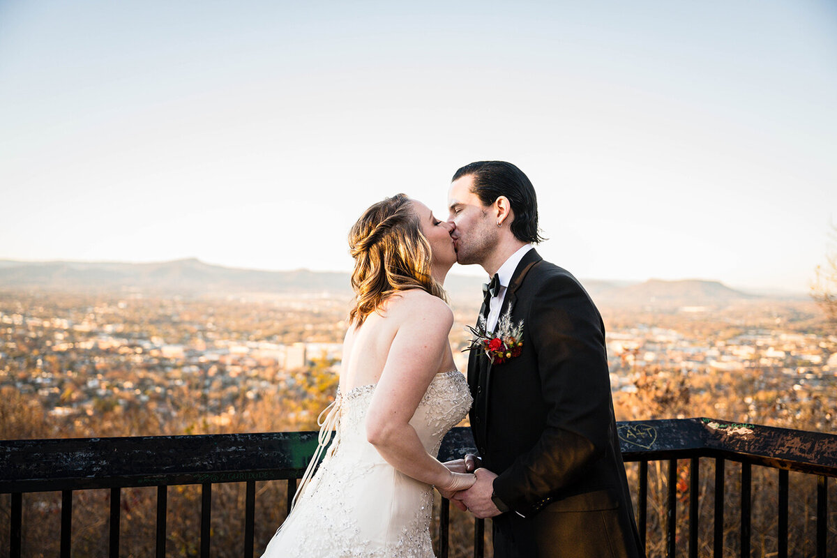 A newlywed couple on their elopement day go in for their first kiss following their sunset ceremony at Rockledge Overlook in Roanoke, Virginia.