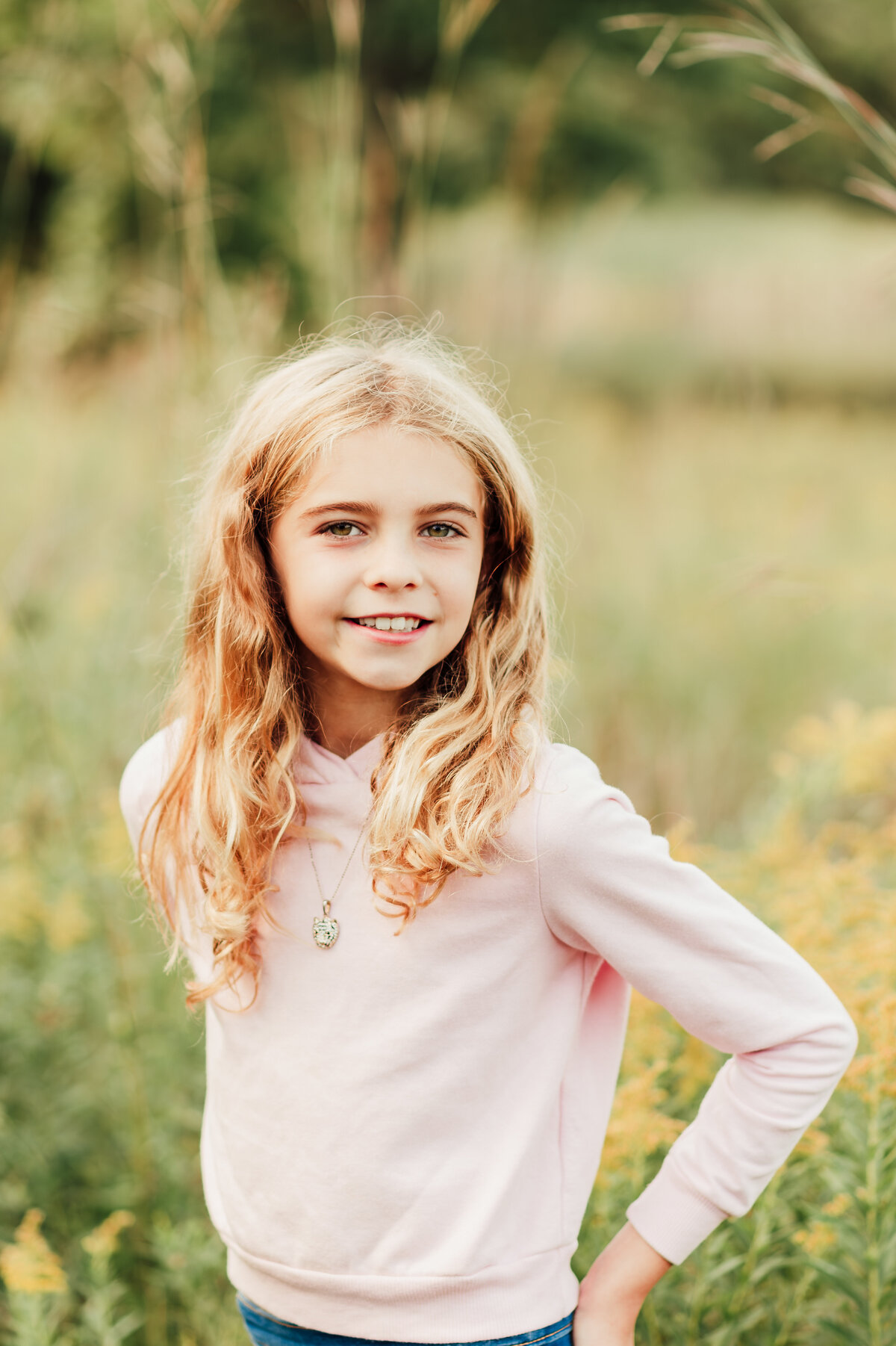 Smiling child posing outdoors for a natural light school portrait in Twin Cities, MN