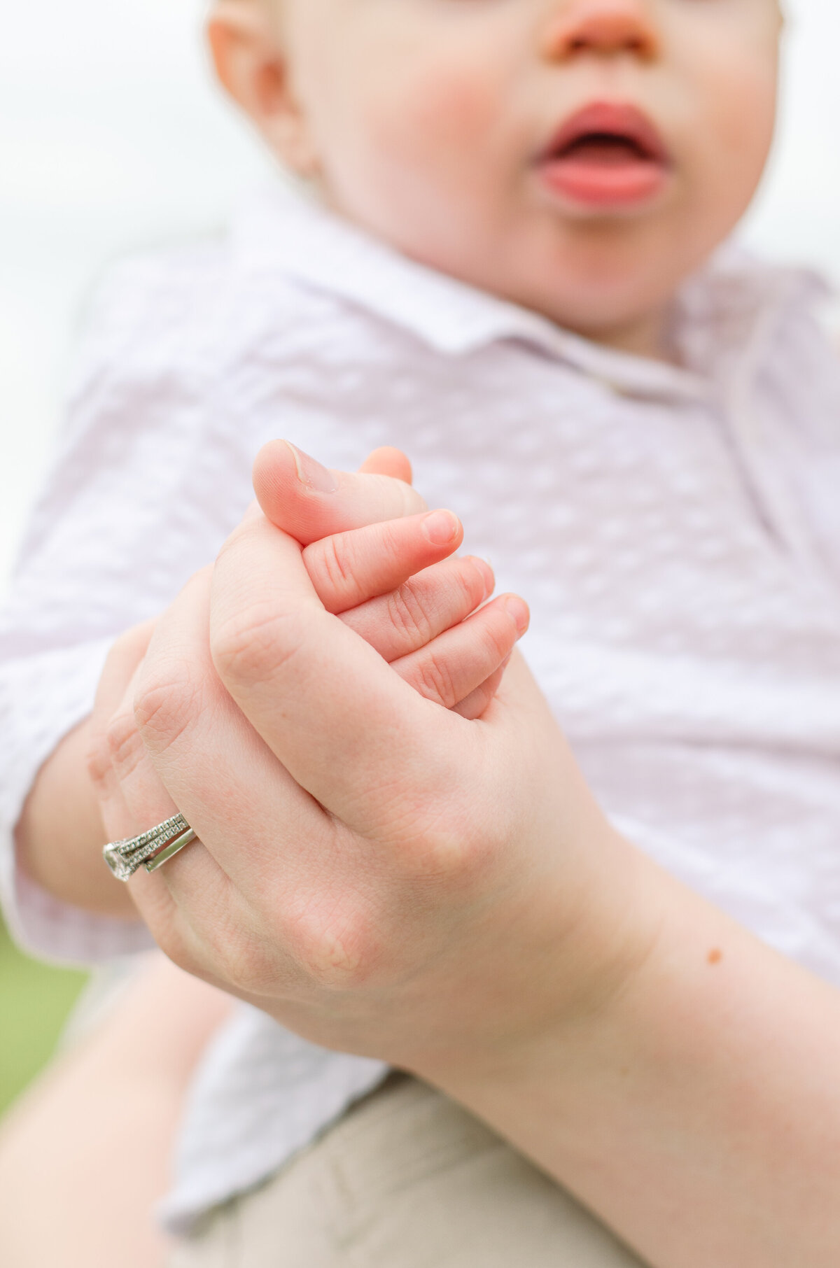 close up of mom holding baby's hand