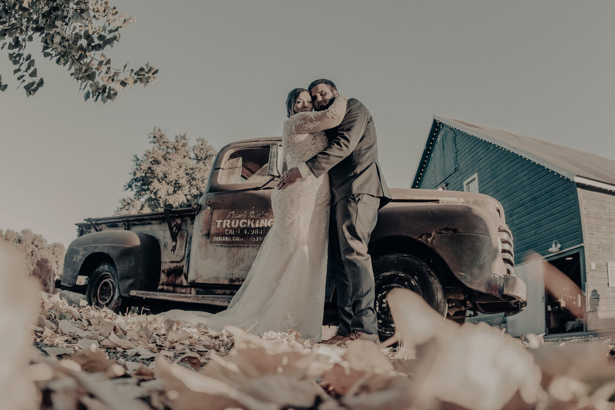 bride and groom in front of old truck