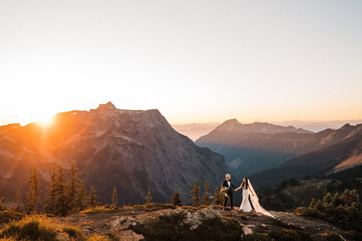 Bride & groom walking along mountain ridge during sunset elopement in the North Cascades!